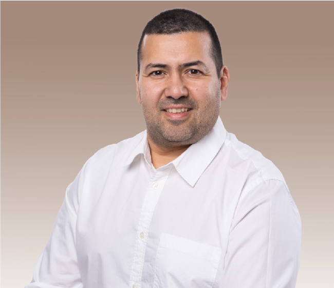 047250ef-4fb8-4927-af73-e8790a478b8a Mann in weißem Hemd lächelt vor einem neutralen Hintergrund. Optimales Porträt für professionelle Profile.