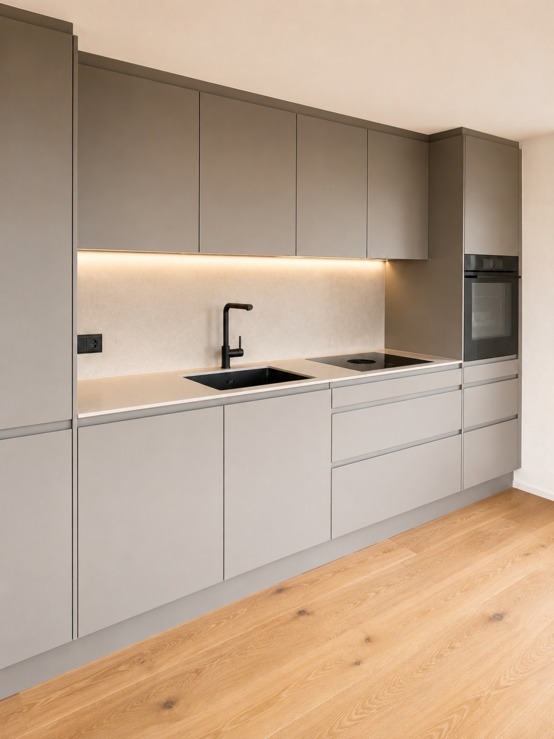 Moderne graue Einbauküche mit Holzfußboden und eingebautem Backofen, stilvolles Design mit eleganter Beleuchtung.