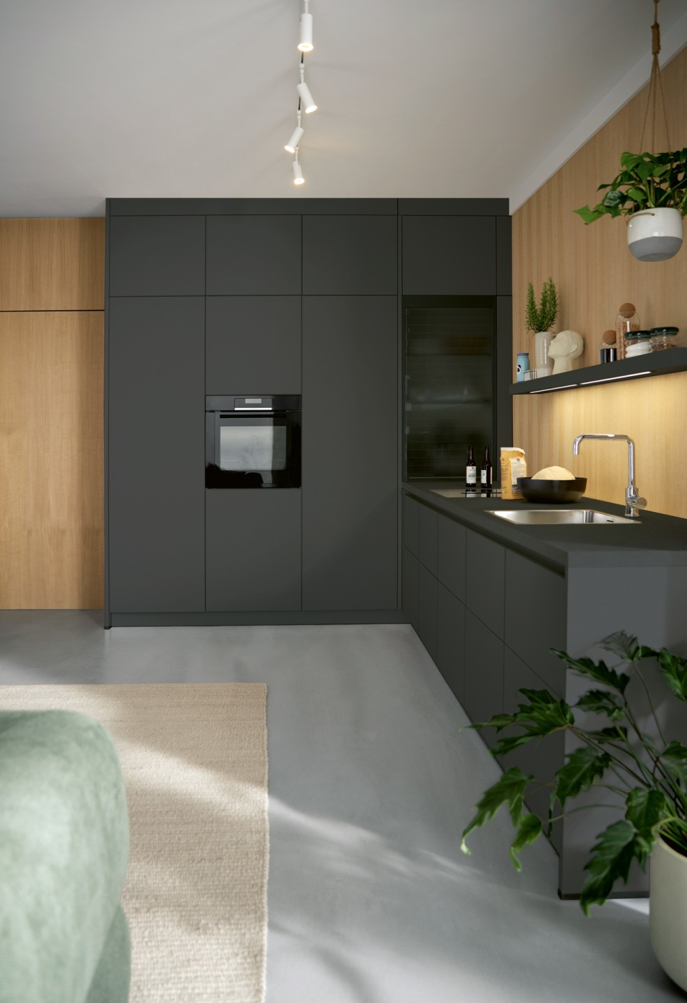 047250ef-4fb8-4927-af73-e8790a478b8a Moderne Küche mit dunklen Schränken, Holzpanelen und grünen Pflanzen. Elegantes und minimalistisches Design.